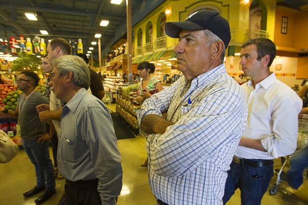 Shopper Umberto Campoy listens to Senate Majority Leader Harry Reid during a news conference in Cardenas  Market at Meadows Lane and Decatur Boulevard Monday, Aug. 27, 2012. Campoy said he was interested in hearing about the Dream Act.