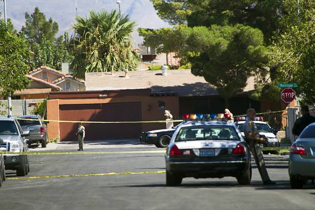 Metro Police officers guard a perimeter after a body was found in a car near Stewart Avenue and Lamb Boulevard Monday, Aug. 27, 2012. 
