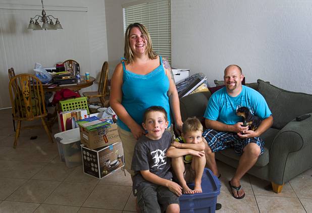 UNLV graduate student Rebecca Lovelady, her sons Theirry, 7, and Preston, 5, and boyfriend Rob Williams pose in their home with donated goods and furniture Tuesday, Aug. 28, 2012. The family lost nearly all their possessions when their moving truck was stolen earlier this month but the Las Vegas community helped out with donated furniture, goods and a fundraiser after their story was broadcast on KNTV-Channel 13 news, she said.