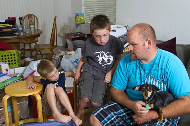 Brothers Preston, 5, and Theirry Lovelady, 7, talk with Rob Williams, their mother's boyfriend, at their home Tuesday, Aug. 28, 2012. The family lost nearly all their possessions when their moving truck was stolen earlier this month but the Las Vegas community helped out with donated furniture, goods and a fundraiser after their story was broadcast on KNTV-Channel 13 news, said Rebecca Lovelady, a UNLV graduate student.