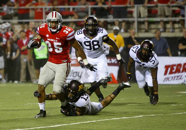 UNLV's Tim Cornett is stopped by Derrick Wells in the second overtime period during UNLV's season opener against Minnesota at Sam Boyd Stadium Thursday, Aug. 30, 2012.