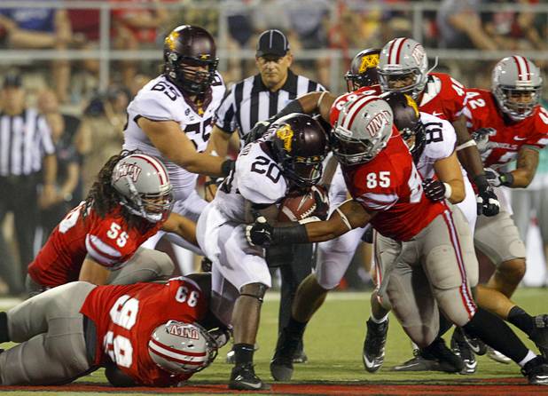 UNLV's Tyler Gaston, bottom left, and Jordan Sparkman stop Minnesota's Donnell Kirkwood during UNLV's season opener against Minnesota at Sam Boyd Stadium Thursday, Aug. 30, 2012.