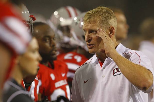 Coach Bobby Hauck talks to players during UNLV's season opener against Minnesota at Sam Boyd Stadium Thursday, Aug. 30, 2012.  
