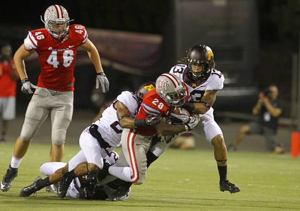 UNLV'S Bradley Randle carries the ball for a first down during UNLV's season opener against Minnesota at Sam Boyd Stadium Thursday, Aug. 30, 2012.  