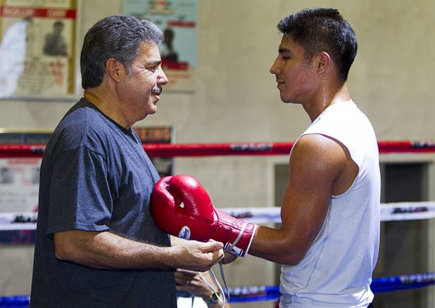 Trainer Robert Alcazar helps Jessie Vargas with his gloves during a workout at Top Rank Gym Tuesday Sept. 4, 2012. Vargas of Las Vegas will fight Aron Martinez of Los Angeles in a 10-round welterweight bout at the Hard Rock Hotel on Thursday, September 13.