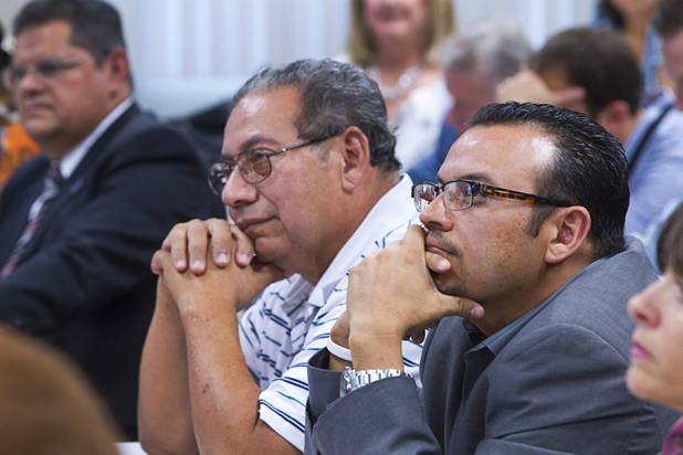 Maximo Zavala, left, and his son Robert listen to Craig Romney, the youngest son of GOP presidential candidate Mitt Romney, during a Hispanic small business dialogue at the Greater Las Vegas Association of Realtors offices Wednesday, Sept. 5, 2012.