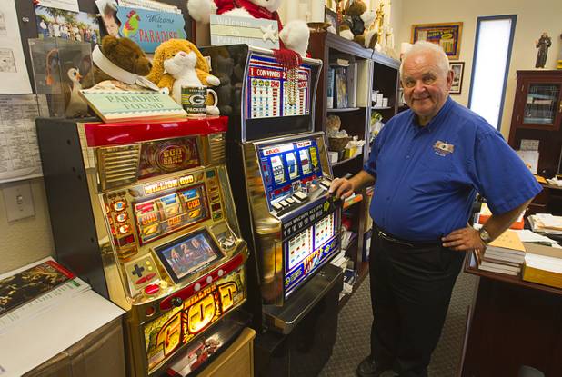 Father Charlie Urnick poses by a God slot machine in his office in Laughlin Sunday, Sept. 9. 2012. The church is the only Catholic church that holds weekly Mass in a casino, said Father Charlie Urnick.
