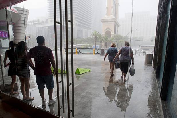 A pair of women brave the rain as they head out to The Strip during a rainstorm Tuesday, Sept. 11, 2012.