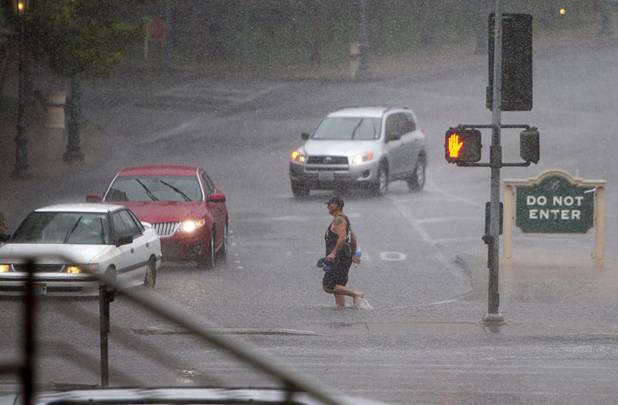 A pedestrian wades through storm run off at an intersection in front of the Bellagio during a rainstorm Tuesday, Sept. 11, 2012.