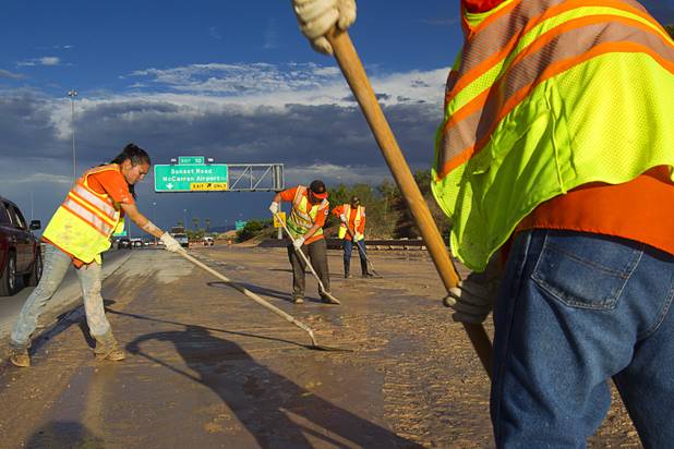A Nevada Department of Transportation crew works to clear the roadway at the I-215 eastbound off-ramp to the airport connector Tuesday, Sept. 11, 2012. Run off from heavy rains filled the roadway with mud and debris.