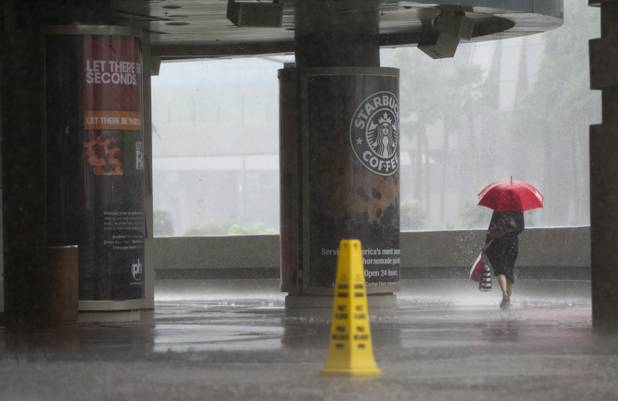 A woman heads southbound on the Las Vegas Strip in front of Planet Hollywood during a rainstorm Tuesday, Sept. 11, 2012.
