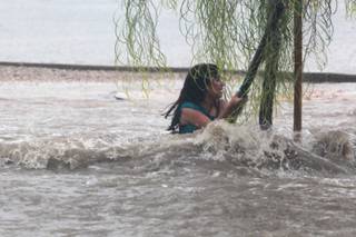 A Knudson Middle School student hangs onto a tree after falling down and being dragged by  floodwater near Eastern and Sahara avenues, Sept. 11, 2012.