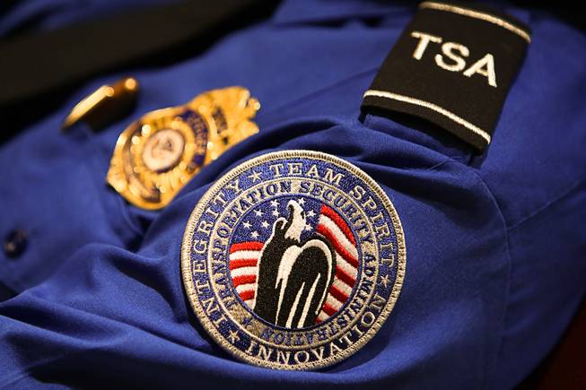 A Transportation Security Administration (TSA) patch and badge are worn ...