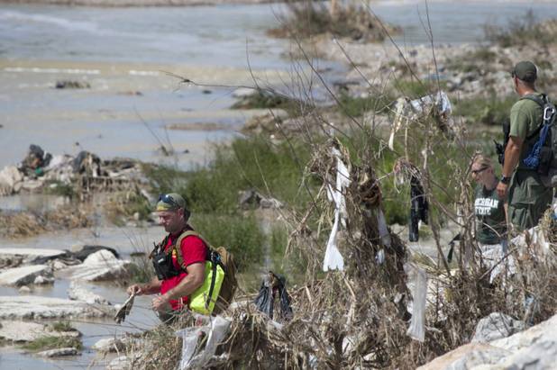 Search and rescue officers walk the Flamingo Wash along the Desert Rose Golf Course as they search for a missing worker Wednesday, Sept. 12, 2012. The worker was working in the wash and was missing after Tuesday's rainstorm and flooding.