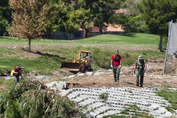 Search and rescue officers walk the Flamingo Wash along the Desert Rose Golf Course as they search for a missing worker Wednesday, Sept. 12, 2012. The worker was working in the wash and was missing after Tuesday's rainstorm and flooding.
