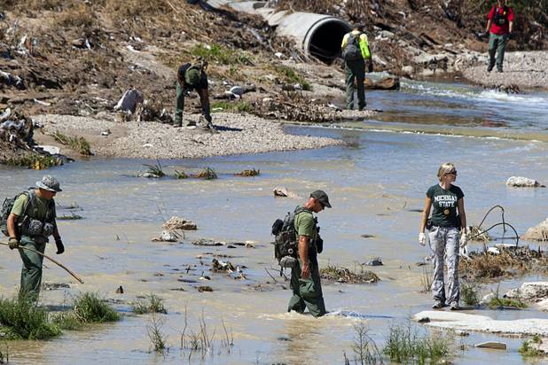 Metro Search and Rescue officers search for a missing golf course worker along the Flamingo Wash near Sloan Lane Wednesday, Sept. 12, 2012. The worker was working in the wash and is missing after Tuesday's rainstorm and flooding.