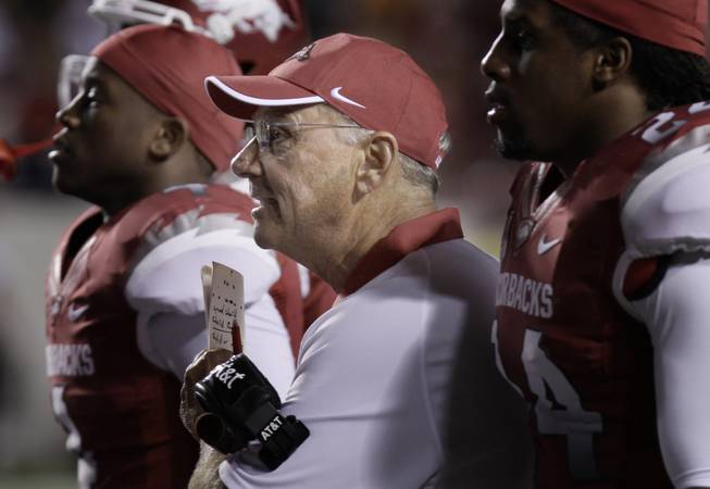 Arkansas coach John L. Smith, center, watches a college football game against Louisiana-Monroe with cornerback Kelvin Fisher, left, and linebacker Daunte Carr during the fourth quarter in Little Rock, Ark. After the loss to the Warhawks, the pressure is on Smith as the suddenly unranked Razorbacks prepare for No. 1 Alabama.