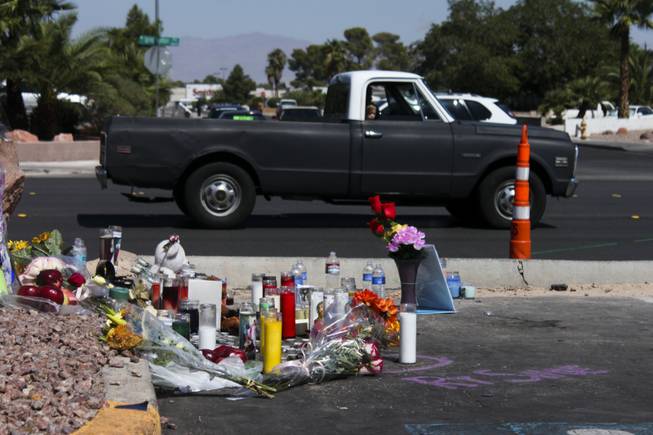 A child looks out onto the memorial site of the bus stop crash from the passenger side of a passing truck Friday, Sept. 14, 2012.