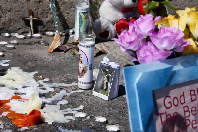 Religous candles along with other mementoes are seen at the memorial site of the bus stop crash Friday, Sept. 14, 2012.