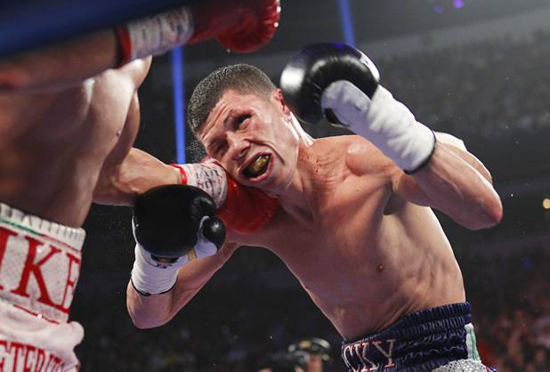 Roman Martinez (R) of Puerto Rico takes a punch from Miguel Beltran Jr. of Mexico during their fight for the vacant WBO super featherweight title at the Thomas & Mack Center in Las Vegas, Nevada Sept. 15, 2012.