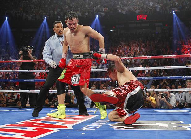 Julio Cesar Chavez Jr. (C) of Mexico moves out of the way after knocking down Sergio Martinez of Argentina during their title fight at the Thomas & Mack Center in Las Vegas, Nevada Sept. 15, 2012.