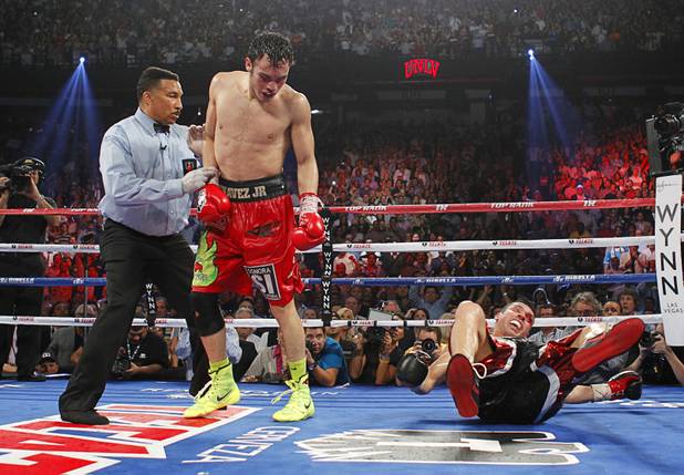 Julio Cesar Chavez Jr. (C) of Mexico is sent to his neutral corner by referee Tony Weeks after knocking down Sergio Martinez of Argentina during their title fight at the Thomas & Mack Center in Las Vegas, Nevada Sept. 15, 2012.