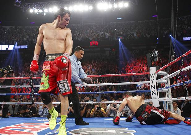 Julio Cesar Chavez Jr. (L) of Mexico walks to his neutral corner after knocking down Sergio Martinez of Argentina during their title fight at the Thomas & Mack Center in Las Vegas, Nevada Sept. 15, 2012.