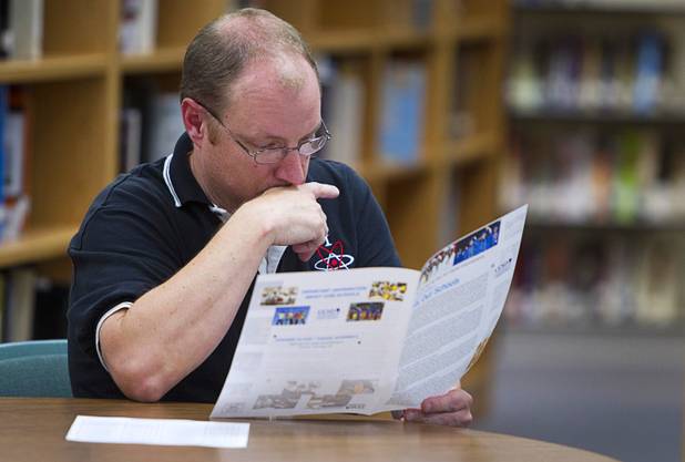Josh Hager, a science teacher at the Las Vegas Academy, looks over information during a Clark County School District meeting at the Bonanza High School library Tuesday, Sept. 18, 2012. CCSD officials answered questions related to a property tax initiative that will be on the ballot in November. The six-year capital levy, if approved, will raise $669 million for high-need school maintenance and renovations. 