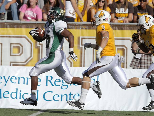 Cal Poly running back Deonte Williams (left) runs away from Wyoming defender Luke Anderson in Cal Poly's 24-22 victory on Saturday, Sept. 15, 2012, in Laramie, Wyo.