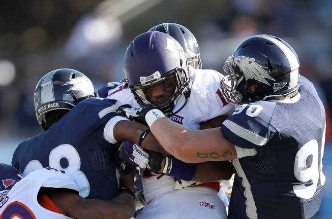 Multiple UNR defenders wrap up Northwestern State's Louis Hollier (17) during the first half of the Wolf Pack's 45-34 victory Saturday, Sept. 15, 2012, in Reno.