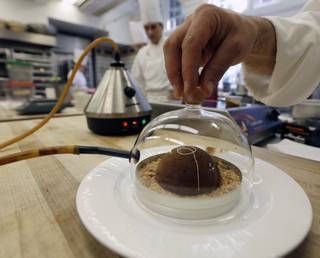 In this image taken on Friday, Sept. 14, 2012, cinnamon aroma is added to a peanut butter and milk chocolate dome dessert at the Culinary Institute of America in Hyde Park, N.Y. This esteemed cooking school north of New York City is dramatically pumping up science instruction, saying that tomorrow's chefs will need more technical know-how in the age of molecular gastronomy and sous-vide. 