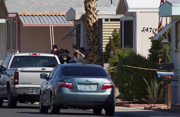 Investigators confer in front of a mobile home after a fire near Nellis Boulevard and Desert Inn Road Wednesday, Sept. 19, 2012. 