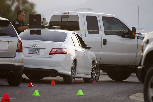 A North Las Vegas Police officer works by a suspect's car, center, at the scene of a fatal officer-involved shooting at Martin Luther King Jr Boulevard and Cheyenne Avenue in North Las Vegas Wednesday, Sept. 19, 2012. 