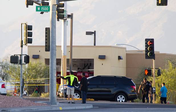 Officials investigate the scene of a fatal officer-involved shooting at Martin Luther King Jr Boulevard and Cheyenne Avenue in North Las Vegas Wednesday, Sept. 19, 2012. 