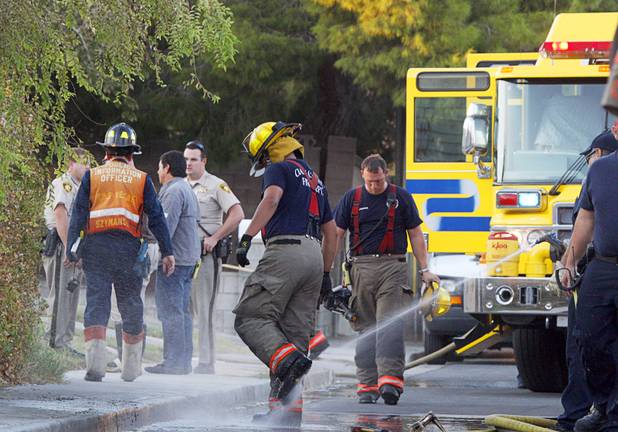 A Clark County firefighter gets his boots washed after fighting a fire that damaged six homes in a neighborhood near Washington Avenue and Pecos Road Sunday, Sept. 23, 2012. Firefighters from the City of Las Vegas Fire Department, Clark County Fire Department, North Las Vegas Fire Department responded to fight the fires. Four people suffered injuries. One cat was killed.