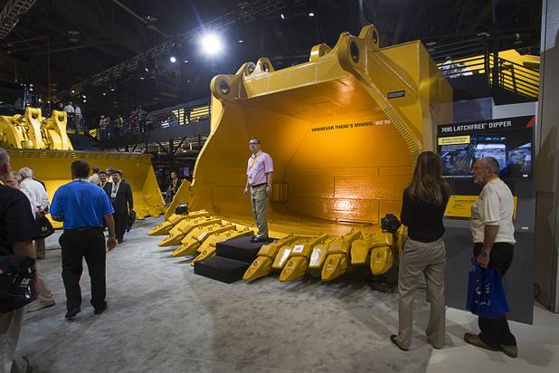 Dmitry Golitsyn of Moscow stands in a new latchfree dipper at the Caterpillar booth during MINExpo International 2012 trade show at the Las Vegas Convention Center Monday, Sept. 24, 2012.