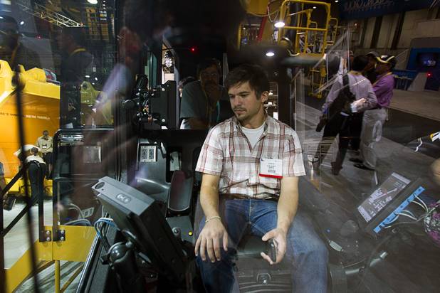 Convention attendee Mark Wiemer sits in the cab of a mining shovel at the Caterpillar booth during MINExpo International 2012 trade show at the Las Vegas Convention Center Monday, Sept. 24, 2012.