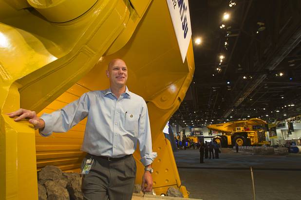 Steve Moster, president of GES. poses by mining equipment in the Komatsu booth during the MINExpo International 2012 trade show at the Las Vegas Convention Center Monday, Sept. 24, 2012.
