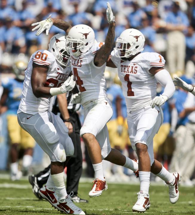 Texas safety Kenny Vaccaro (4) celebrates making an interception off a pass by UCLA quarterback Kevin Prince (4) with teammates Keenan Robinson (1) and Alex Okafor (80) in this file photo.