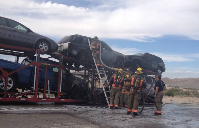 Clark County Fire Department firefighters check over smoldering automobiles that had caught fire on a tractor-trailer Friday afternoon, Sept. 27, on Interstate 15 near the M Resort.