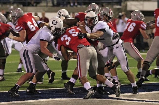 Utah State linebacker Jake Doughty, left, and other Utah State players tackle UNLV running back Tim Cornett (35) for a safety in the fourth quarter of an NCAA college football game Saturday, Sept. 29, 2012, in Logan, Utah. Utah State  defeated UNLV  35-13.   (AP Photo/Rick Bowmer)