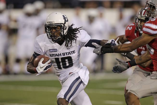 Utah State wide receiver Chuck Jacobs (10) pulls away from UNLV defensive backs Peni Vea (42) and Tajh Hasson (29) on his way to a touchdown in the second quarter of an NCAA college football game Saturday, Sept. 29, 2012, in Logan, Utah.  (AP Photo/Rick Bowmer)