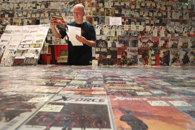 A man who declined to give his name bags up a comic book in his store's booth at the Las Vegas Comic Expo Saturday, Sept. 29, 2012.