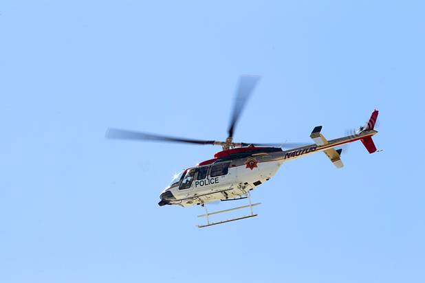 A Metro Police helicopter patrols above McCarran International Airport after Air Force One lands at the airport Sunday, Sept. 30, 2012. President Barack Obama will attend a campaign rally then stay in Henderson as he prepares for his first debate with Republican presidential candidate Mitt Romney. The debate will be held in Colorado Wednesday.