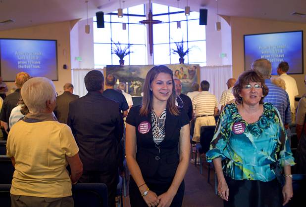 Intern Pastor Kaitlyn Ferguson, center, and Pastor Marta Poling-Goldenne walk through the congregation at the conclusion of the first service at New Song Church in Henderson Sunday, Sept. 30, 2012.