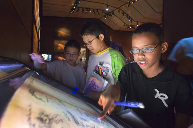 Hyde Park Middle School students, from left, Jeff Luo, Tenichi Mata, and Willie Chalmers III, look over an exhibit during a visit to the "Da Vinci- The Genius" at the Imagine Gallery in the Venetian Monday, Oct. 1, 2012. This week, all Hyde Park sixth graders, who have been studying about  Leonardo Da Vinci for about a month, will visit the exhibit. The traveling exhibit has been extended through January, a representative said.