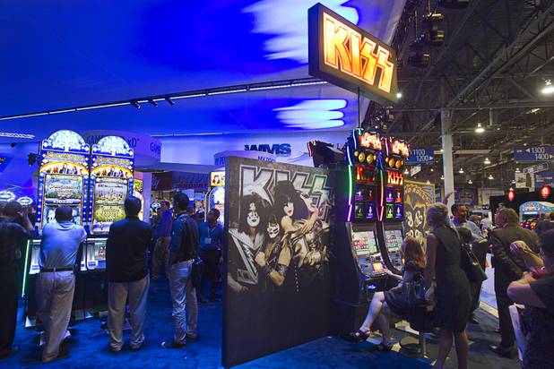People try out the new KISS-themed slot machine at the WMS Gaming booth during the Global Gaming Expo (G2E) at the Sands Expo Center Tuesday, Oct. 2, 2012.