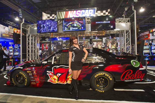 Amanda McIlvaine poses by a car promoting the NASCAR-themed slot machines at the Bally Technologies booth during the Global Gaming Expo (G2E) at the Sands Expo Center Tuesday, Oct. 2, 2012.