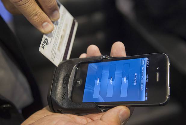 Christopher Wolfington, CEO of Money Centers of America, demonstrates the company's smart phone App during the Global Gaming Expo (G2E) at the Sands Expo Center Tuesday, Oct. 2, 2012.