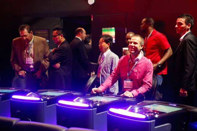 An exhibitor plays a round of Keno on Interblock's electronic gaming machine and watches the results on a life-size holographic display, Thursday Oct. 4, 2012.